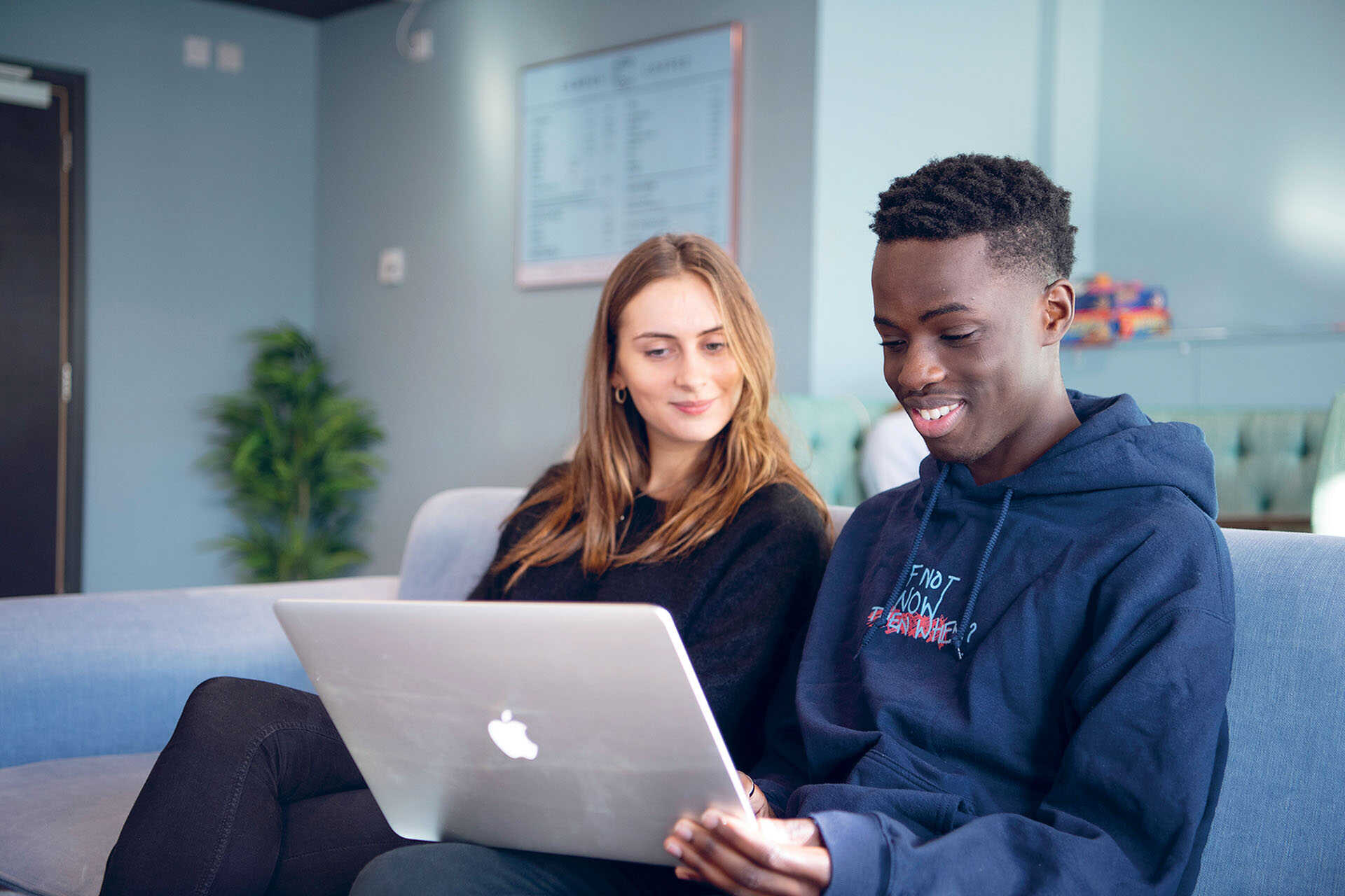 Two students working at a laptop