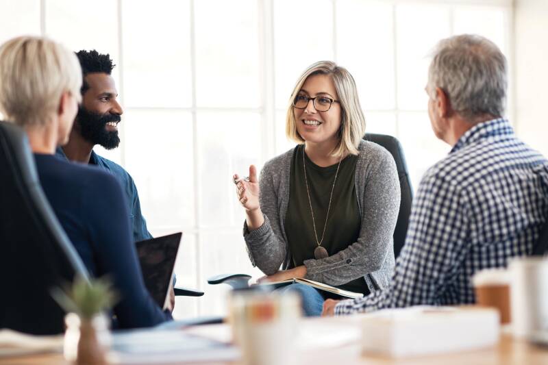 Four members of staff talking around a desk.