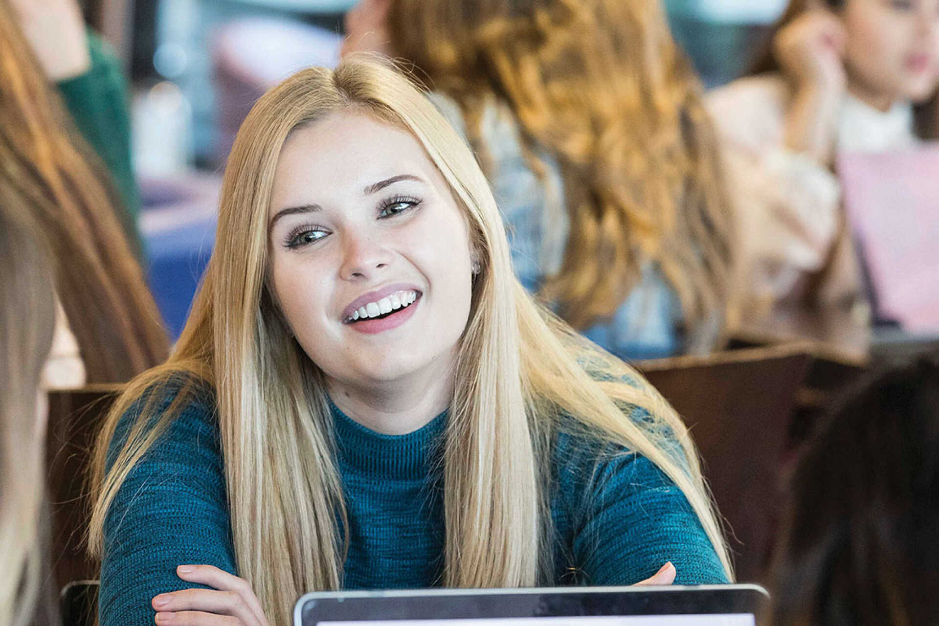 Smiling female student chatting to friends