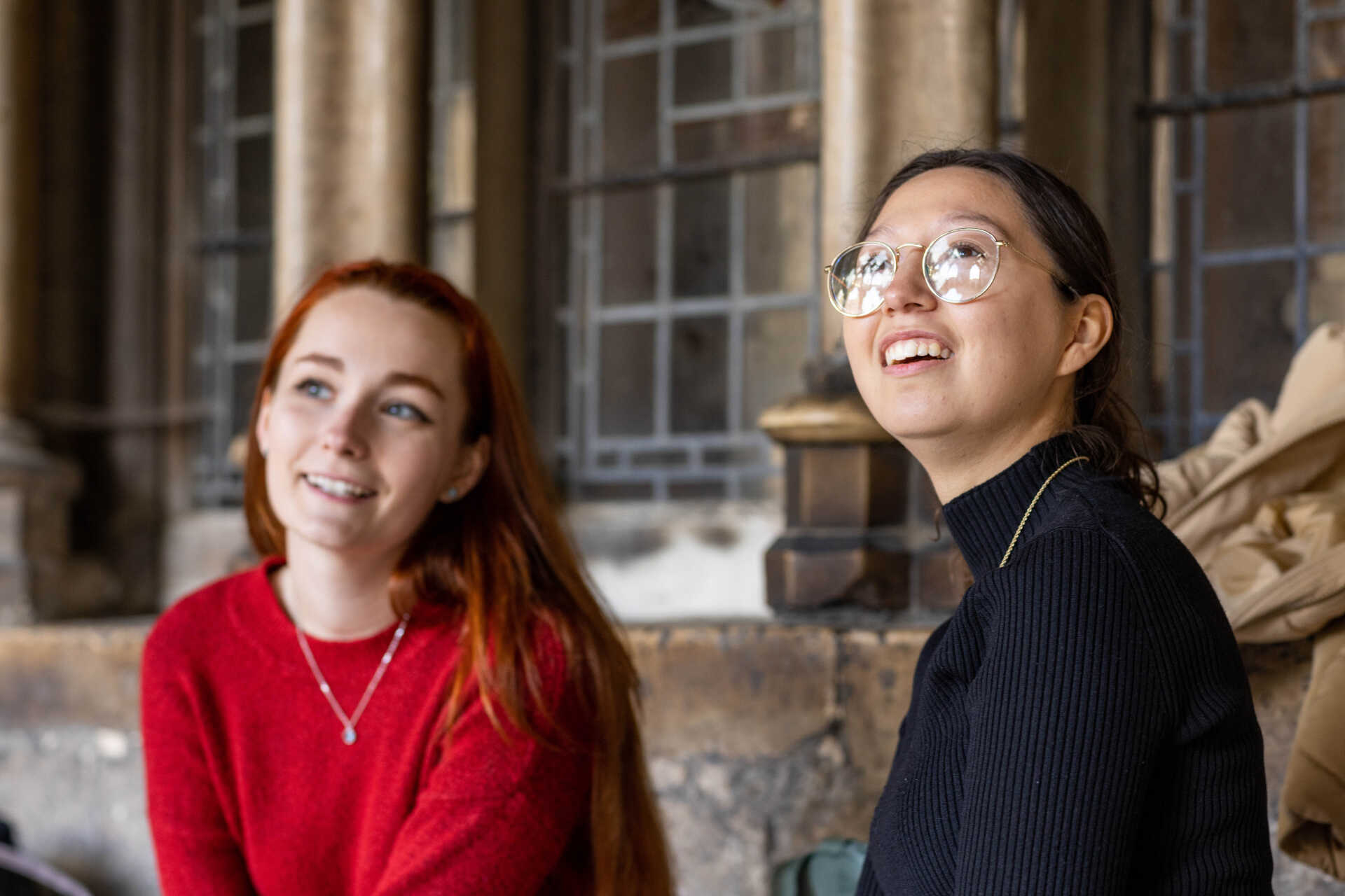 Two students looking to the horizon from a bench within the Cathedral grounds