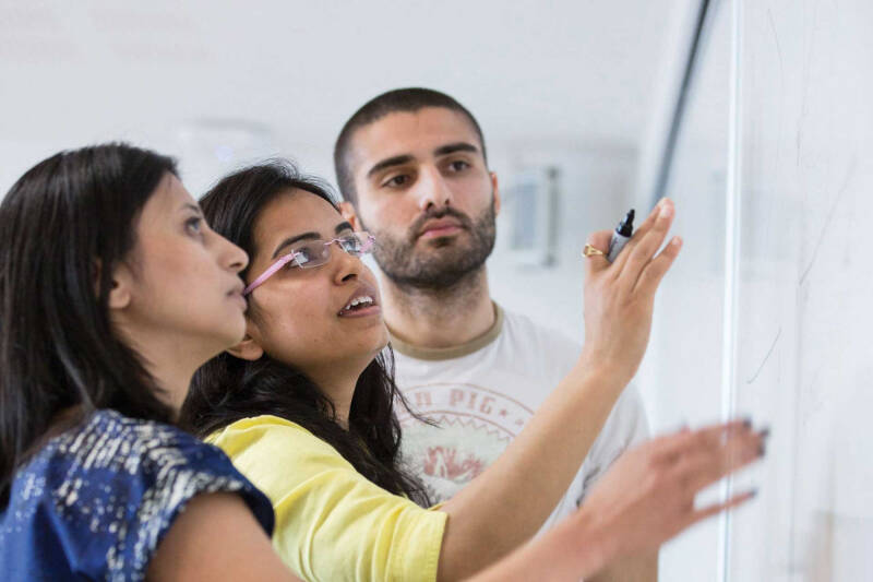 Students discussing at white board